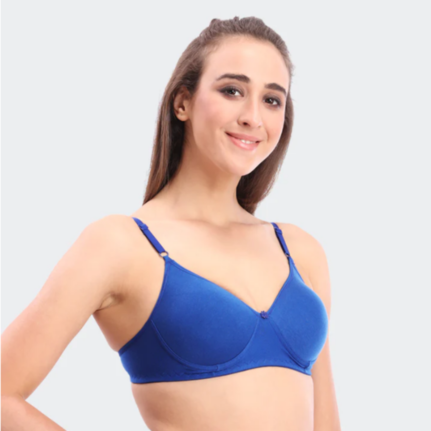 Woman wearing a blue bra against a light gray background
