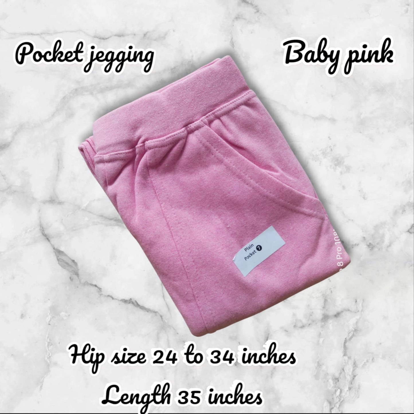 Folded pink pocket jegging on a marble background with product details.