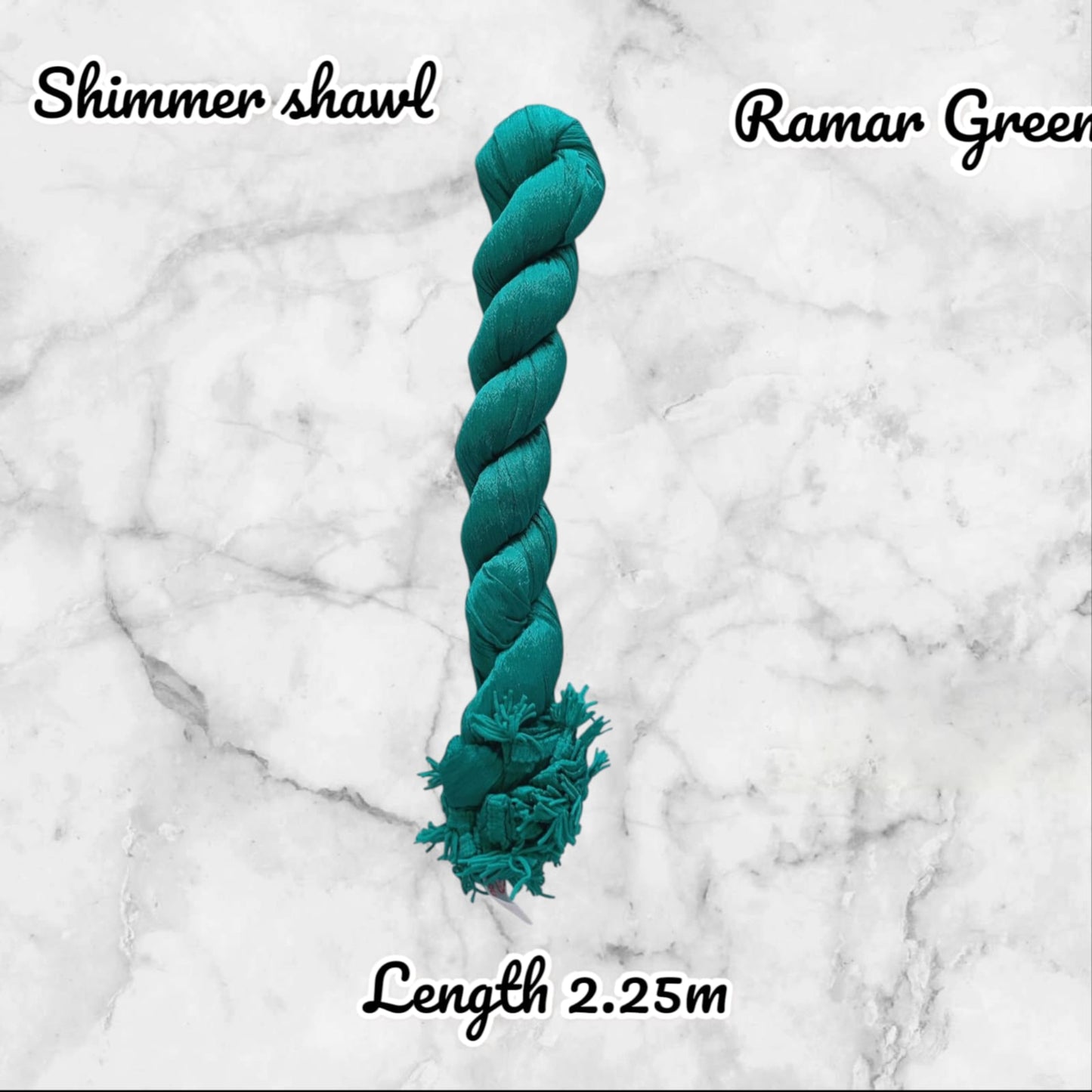 Teal braided toy with 'Shimmer shawl Ramar Green' text on a marble background