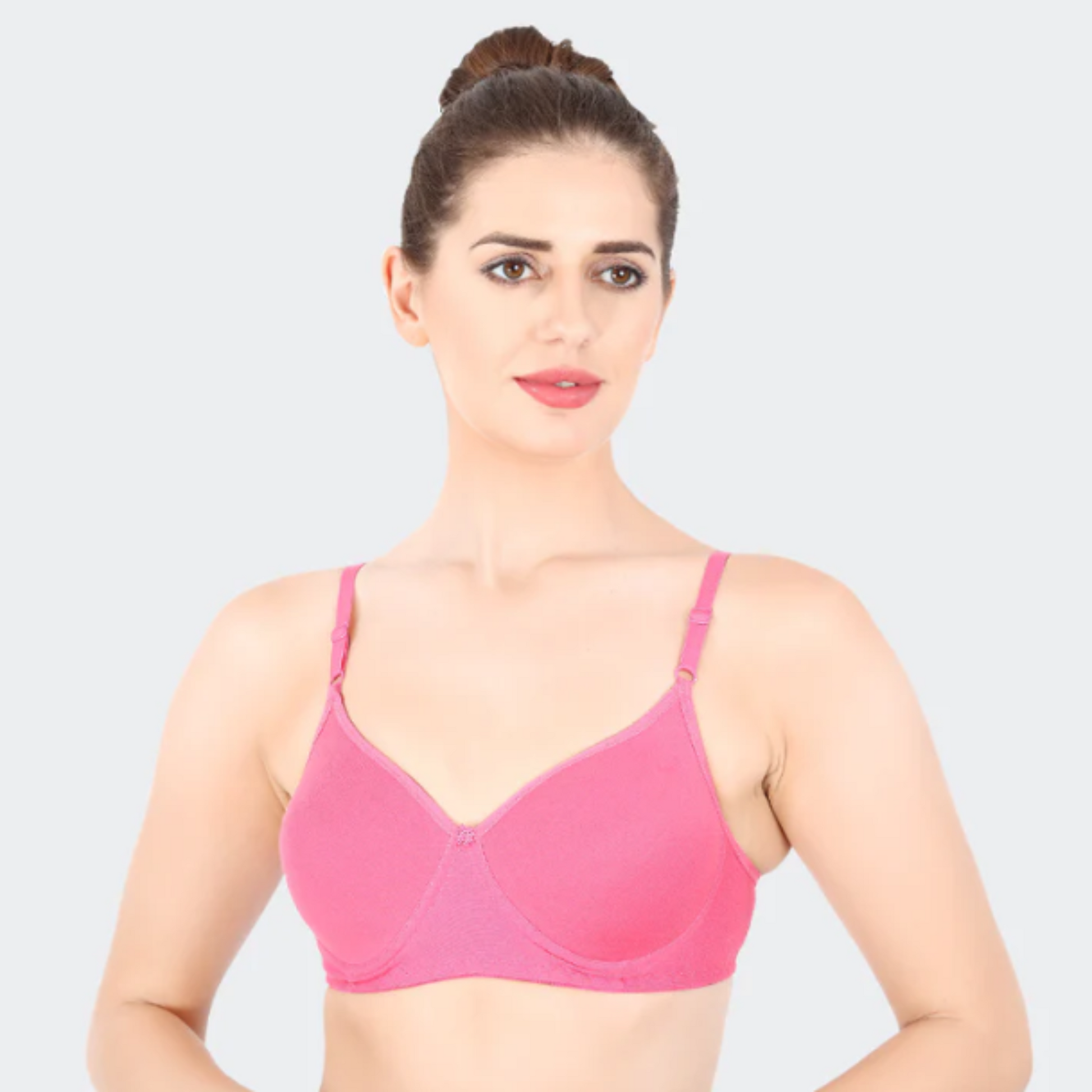 Woman wearing a pink bra against a light gray background