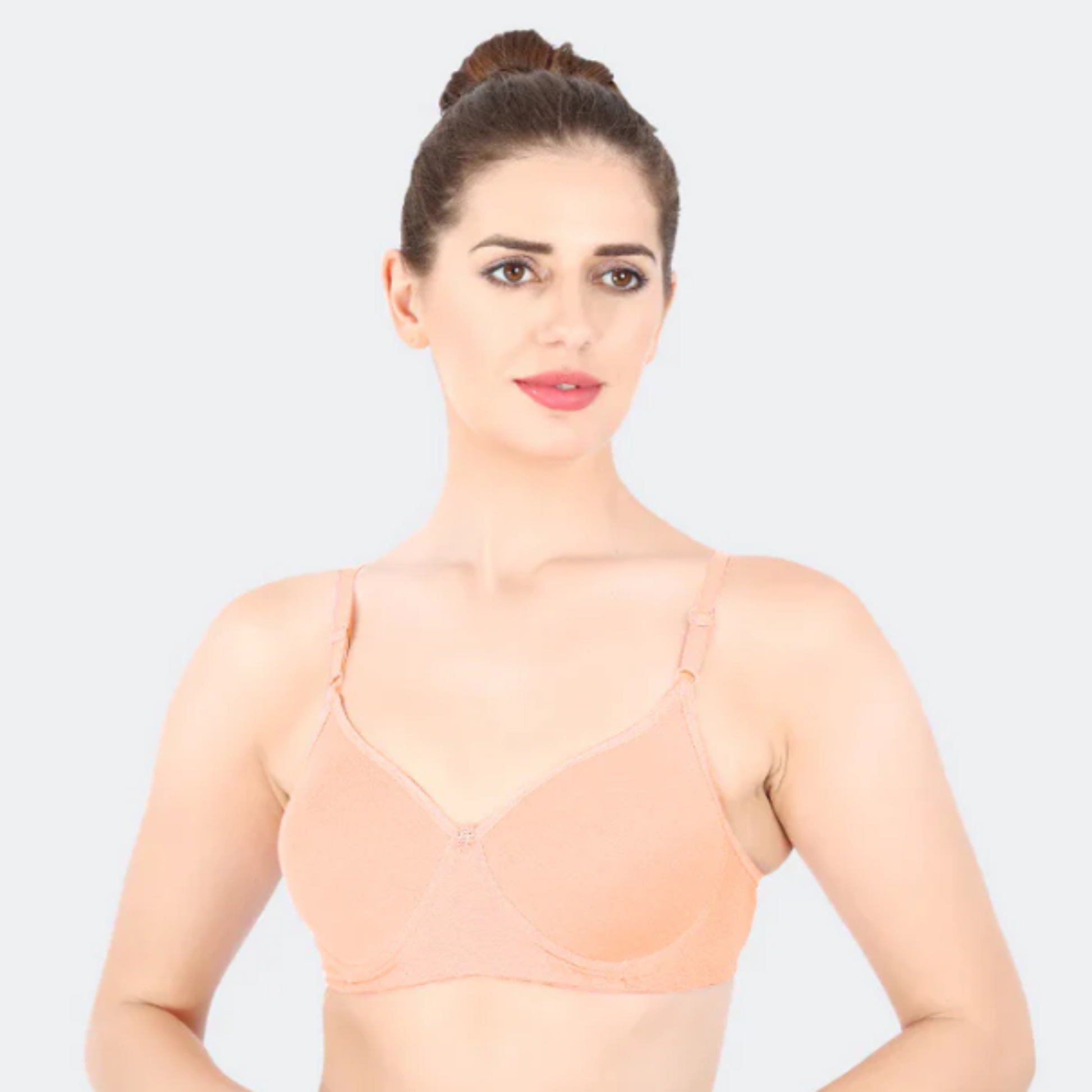 Woman wearing a beige underwire bra against a white background