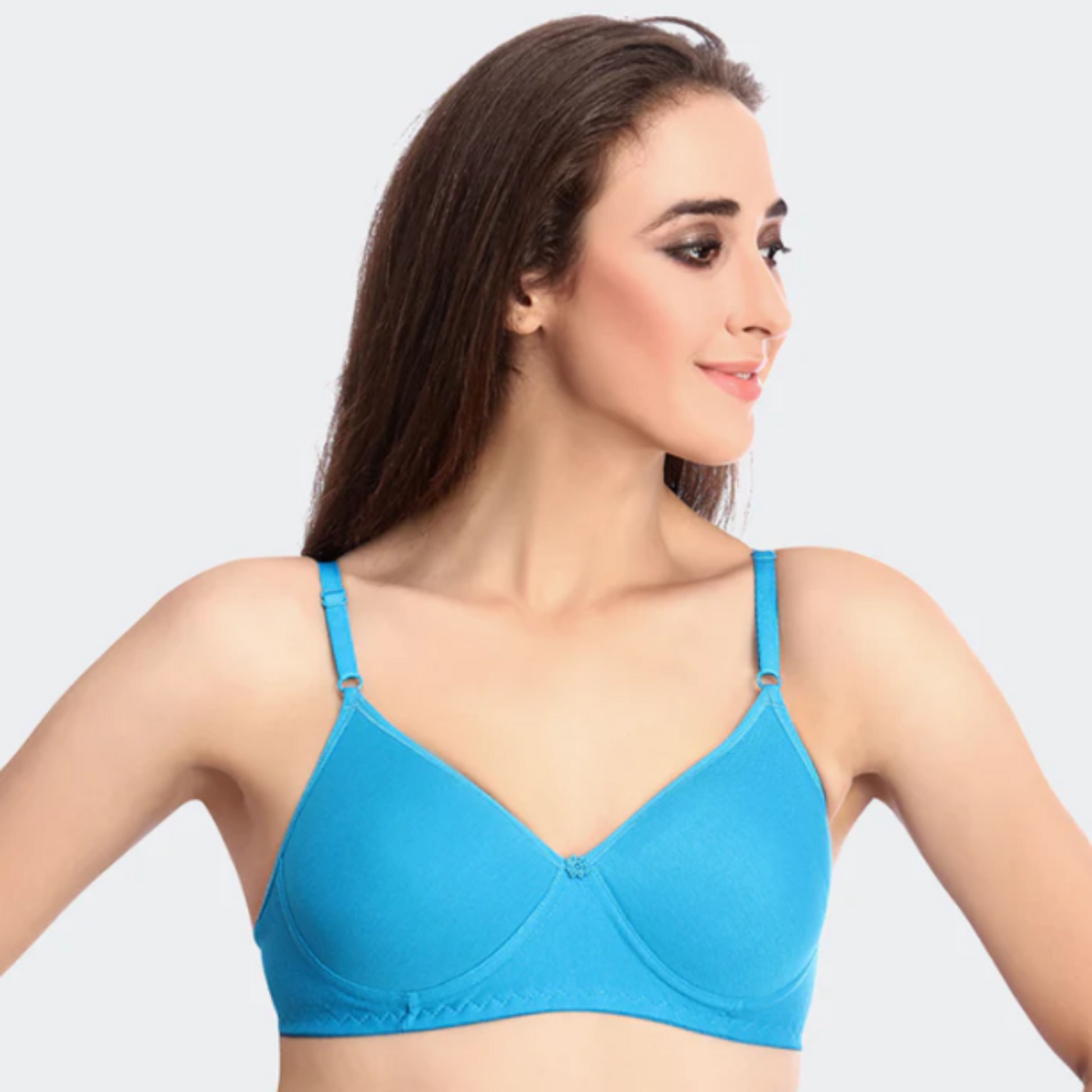 Woman wearing a blue bra against a light gray background