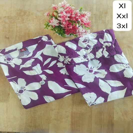 Purple pants with white floral pattern on a wooden surface, with flower arrangement and size chart.
