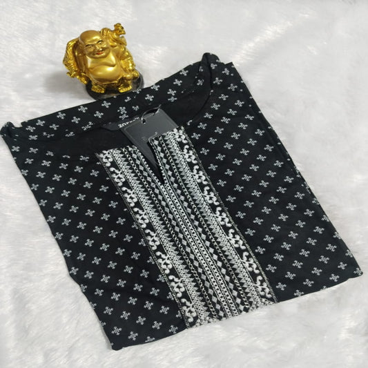 Black fabric with white patterns and silver embellishments on a textured white background