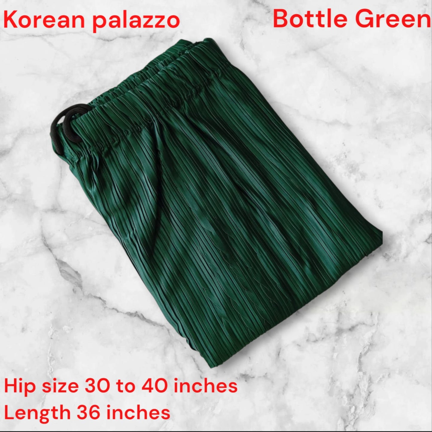 Green palazzo pants on a marble surface with text indicating color and size information.