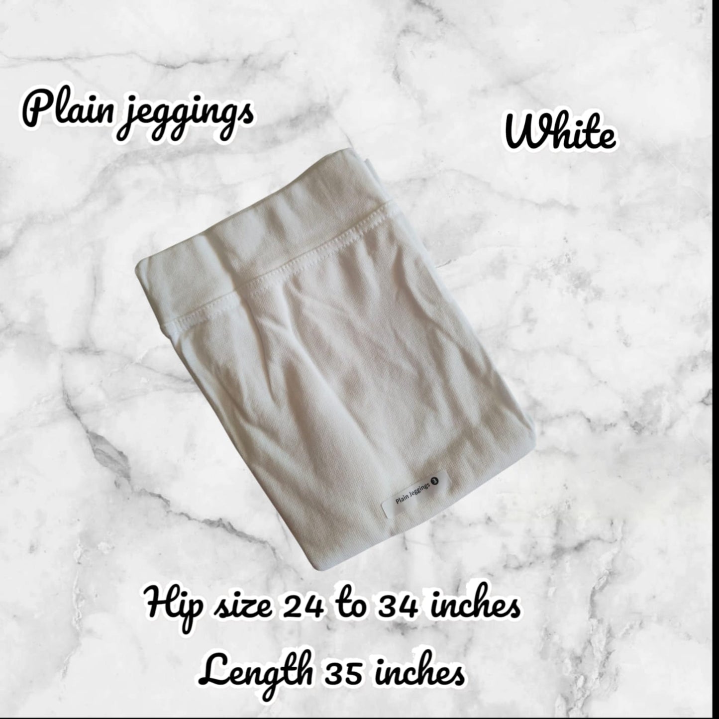 White plain jeggings on a marble background with text indicating size and length.