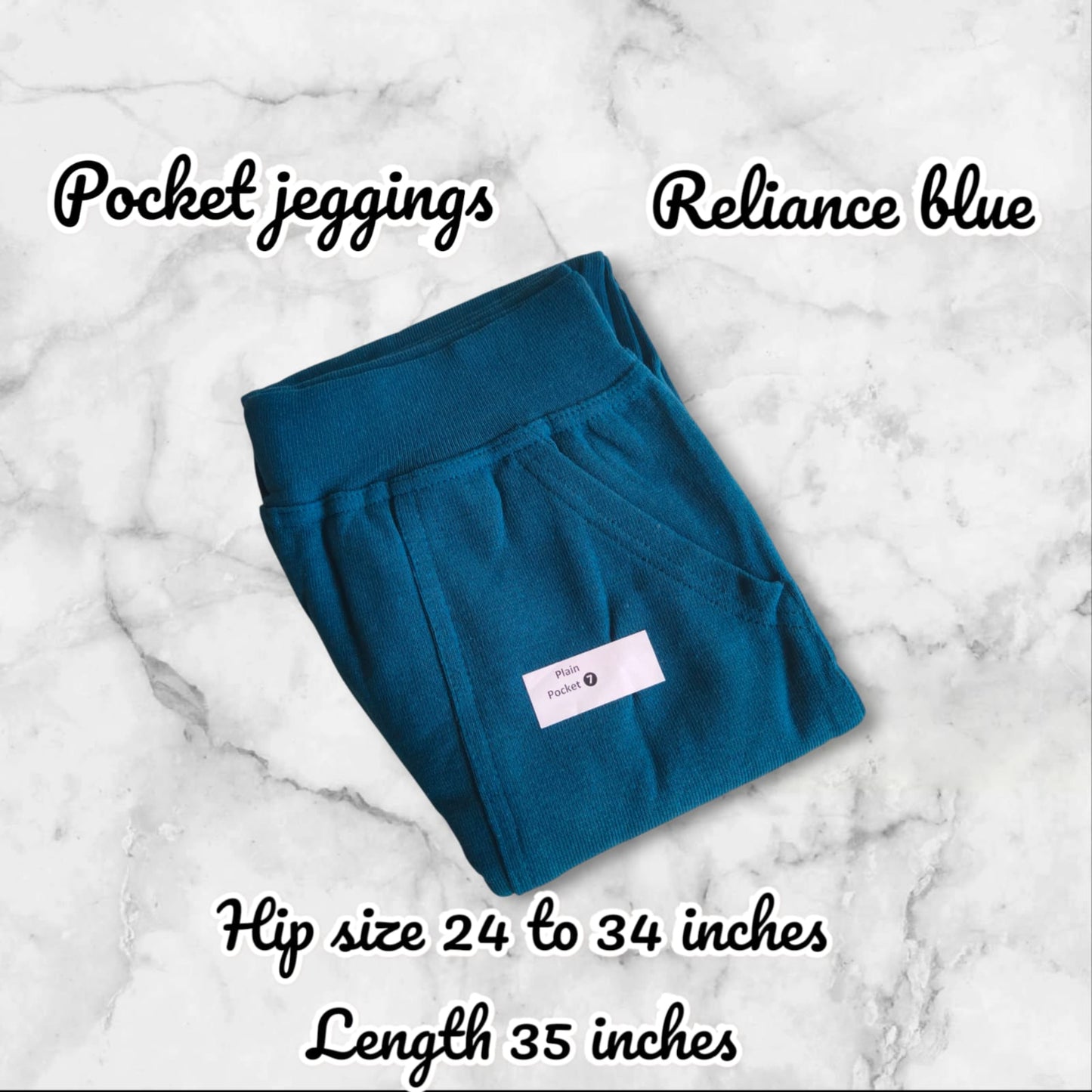 Teal pocket jeggings with a label on a marble background