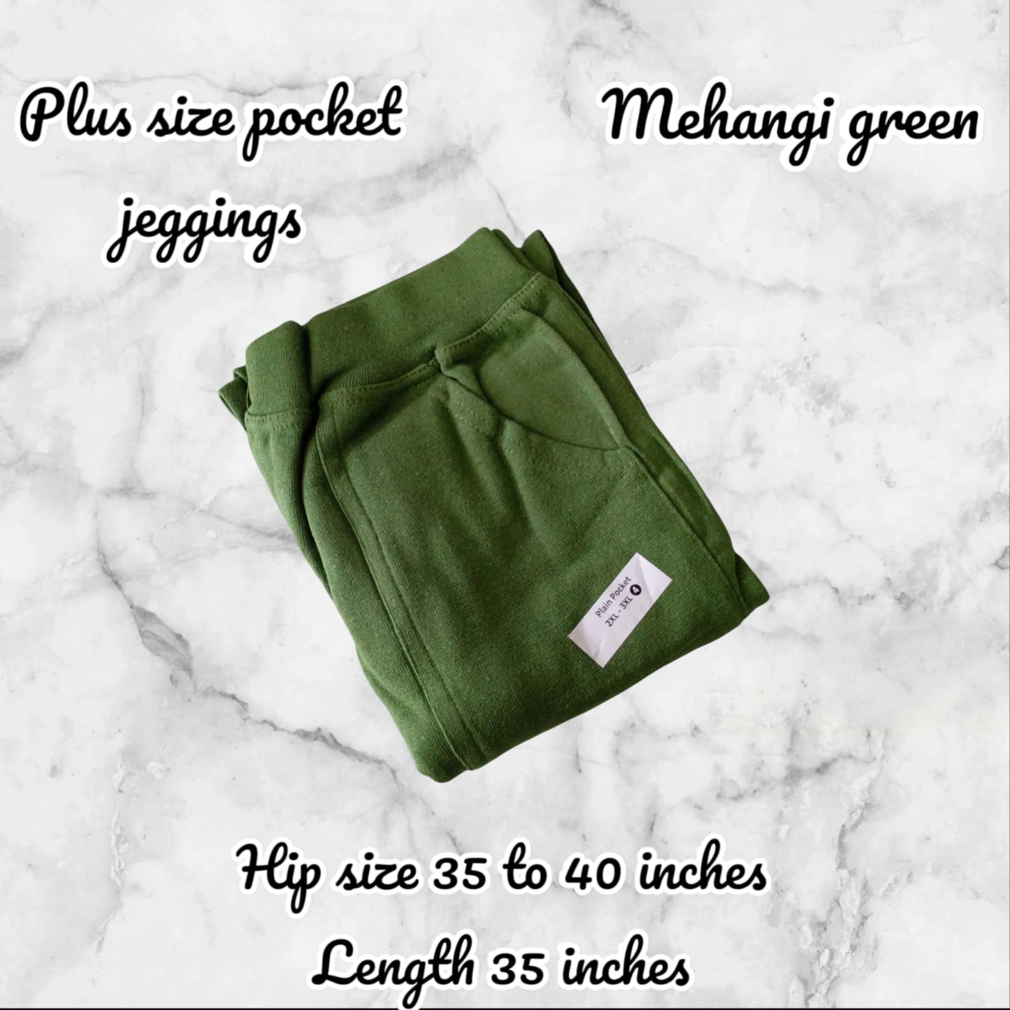 Folded green plus size pocket jeggings on a marble background with product details.