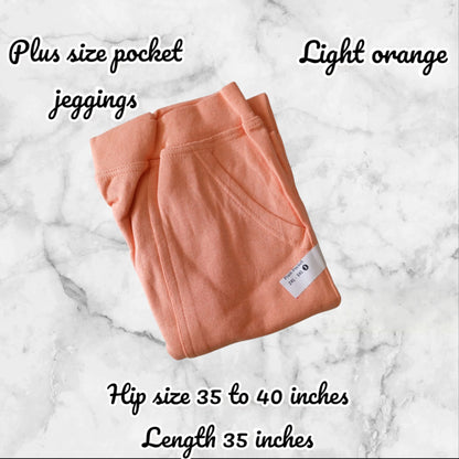 Light orange plus size pocket jeggings on a marble background with product details.