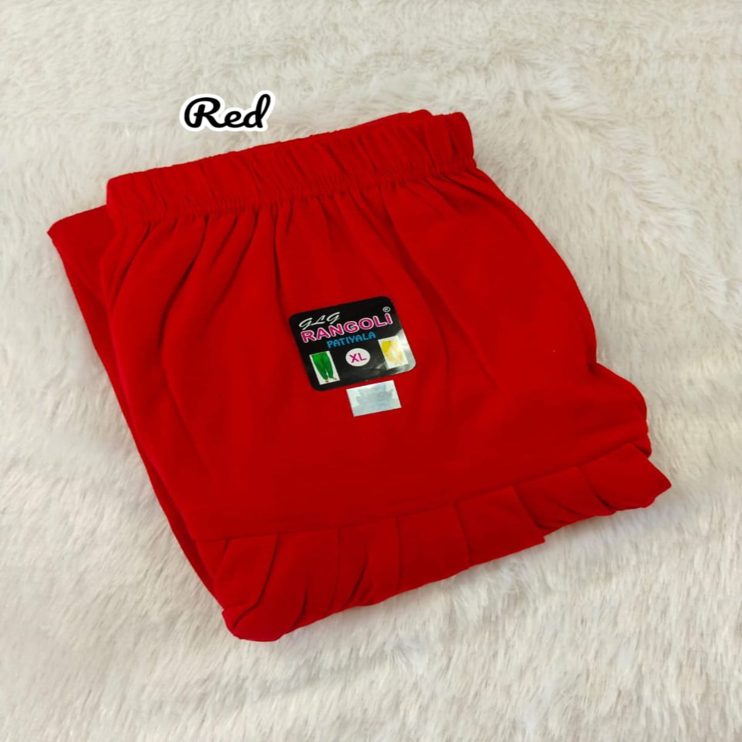 Folded red pants with a label on a light background