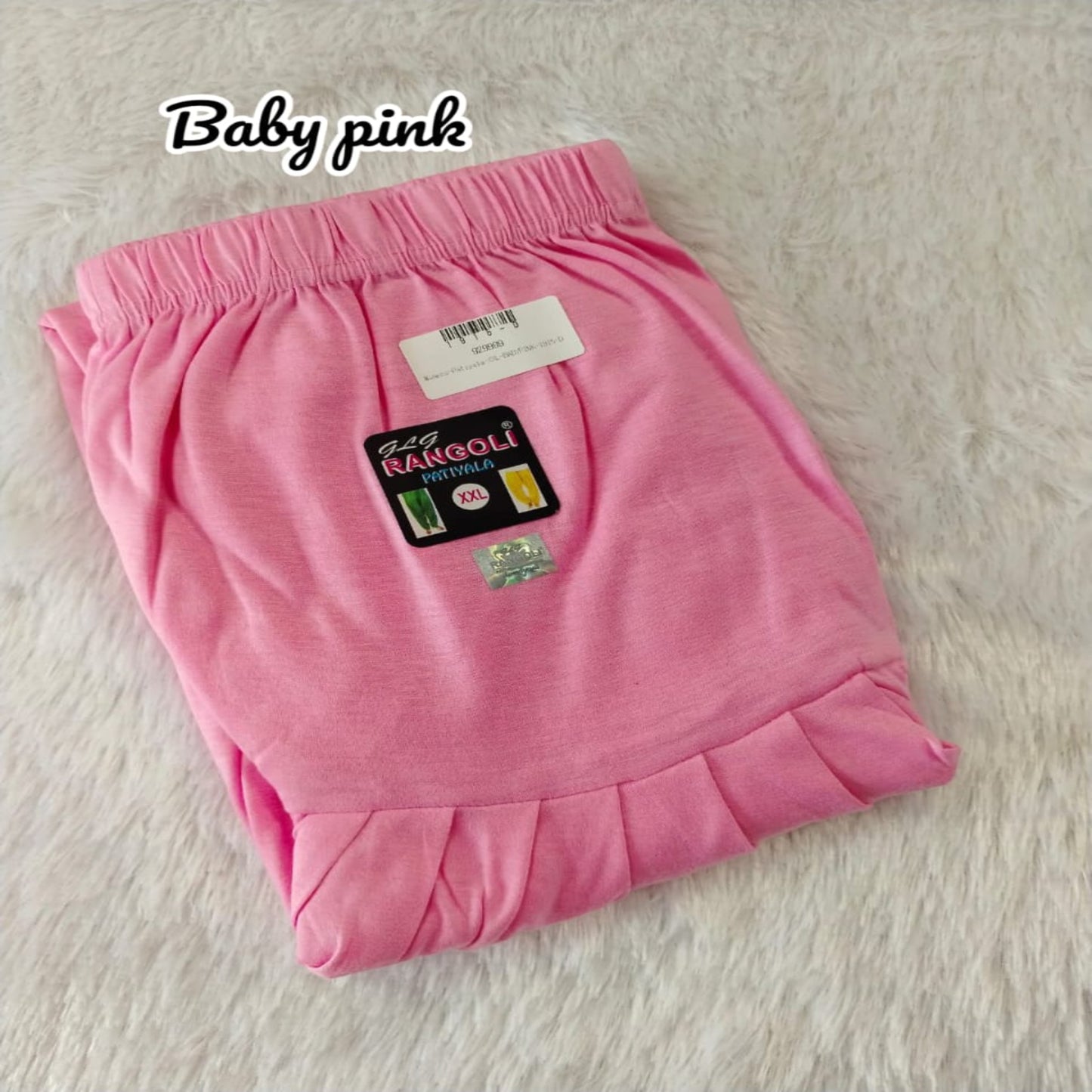 Folded pink pants with a label on a light background